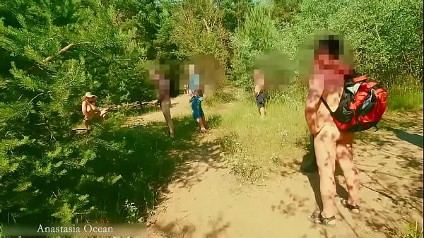 A nudist girl walks in forest near the beach among dressed people. (Emerald Ocean) videos