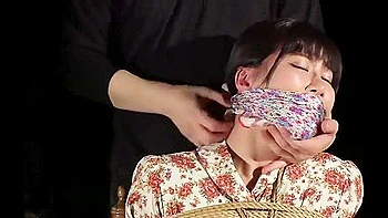 She is tied up, her breasts are exposed, touched, and a vibrator is inserted into her. videos